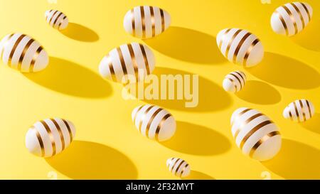 Minimal creative concept pattern made of white eggs with gold stripe against yellow background. Bright direct light with long shadow. Stock Photo