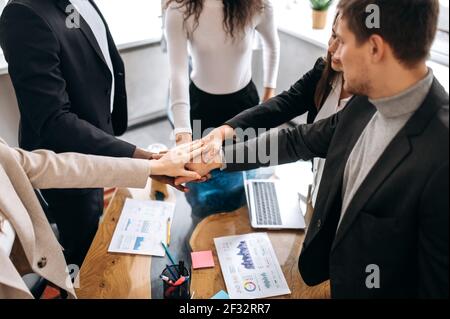 Concept of successful business team coming to agreement on briefing, putting their hands together, making a deal. Multiracial colleagues done a great work, successful negotiations concept Stock Photo