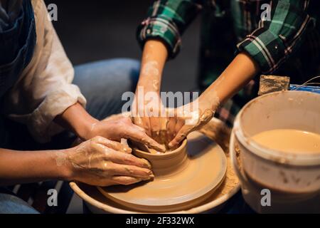 the older sister and her younger brother spend time in a pottery workshop, making clay dishes. Stock Photo