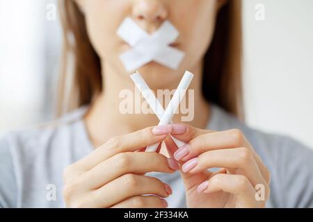 Stop smoking, woman cuts a cigarette with scissors Stock Photo