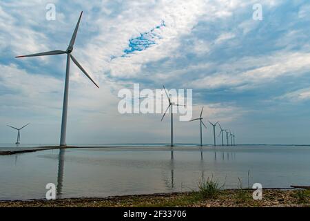 Modern windmills built on a narrow dam on the west coast of Denmark, Nissum Bredning Bay Stock Photo