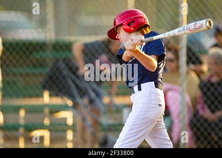 A red-headed teenage boy batting during a baseball game. Stock Photo