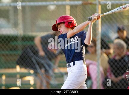 A red-headed teenage boy batting during a baseball game. Stock Photo