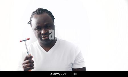 African american black man with crossed hands over the chest holding medical reflex hammer. Isolated on white background. High quality photo Stock Photo