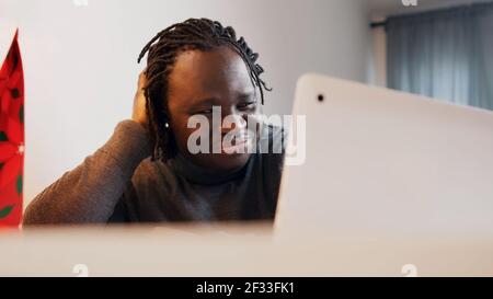 Young african american black man smiling while having video call. Online dating concept. Presenting the gift box. High quality photo Stock Photo