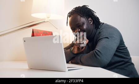 Young african american black man having a video call using laptop. Showing gift to his girlfriend. High quality photo Stock Photo