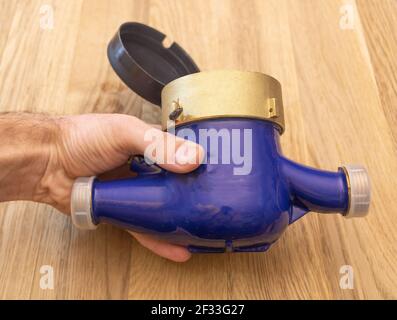 A new unused water meter in the hand of a man Stock Photo