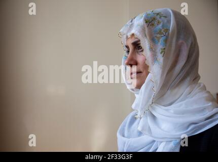 Wearing an embroidered headscarf, the woman drinks her coffee After breaking Ramadan fast. Women in hijab after iftar. Stock Photo