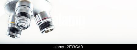Detail of microscope lens on an isolated white background. Stock Photo