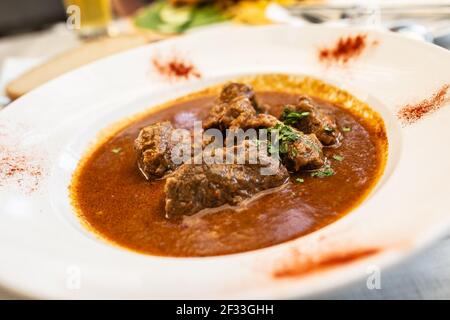 Beef stew with large chunks of meat served in a white plate. Stock Photo