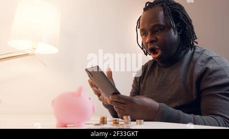 African american black man checking bank balance using mobile app. Investing and wealth growth concept. High quality photo Stock Photo