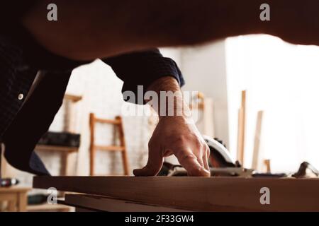 Male carpenter working with a wooden bar in a workshop Stock Photo