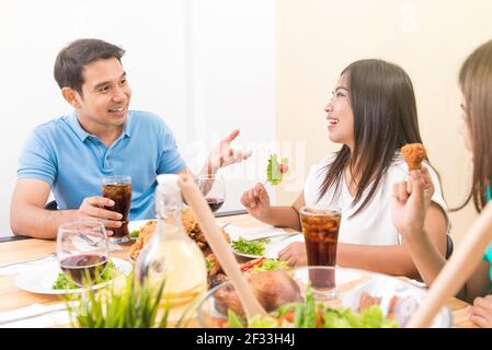 People enjoying eating and having conversation at dining table Stock Photo