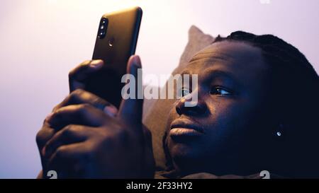African american black man using smartphone while resting on the couch. High quality photo Stock Photo