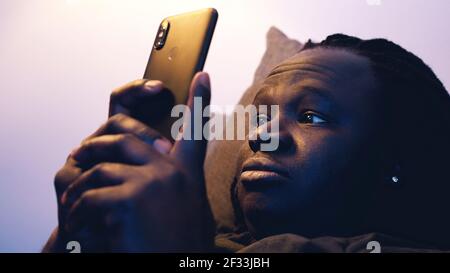 African american black man using smartphone while resting on the couch. High quality photo Stock Photo