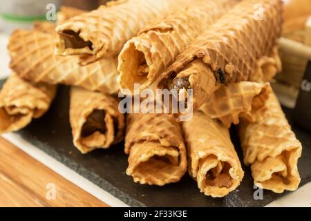 Homemade waffle rolls with condensed milk on buffet. Stock Photo