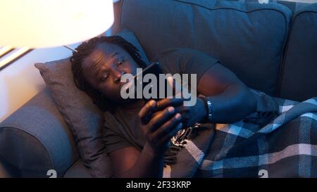 Sick african american man turning on the couch. High fever, illness covid-19. High quality photo Stock Photo