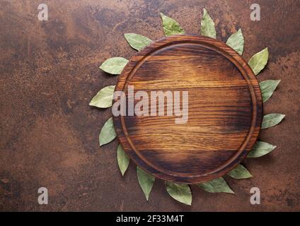 Pizza or bread cutting board and laurel leaf for homemade baking on table. Food recipe concept at stone or marble background texture with copy space. Stock Photo