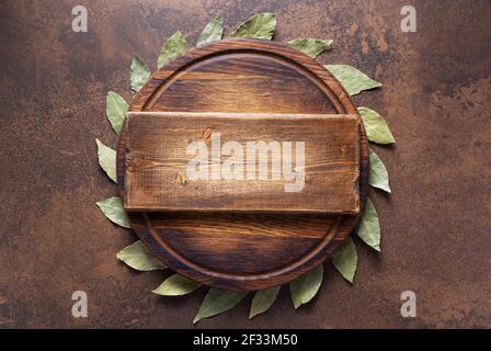 Pizza or bread cutting board and laurel leaf for homemade baking on table. Food recipe concept at stone or marble background texture with copy space. Stock Photo