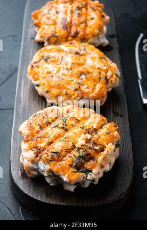 Cooked fish patties, with salmon and lemongrass, on black textured background Stock Photo