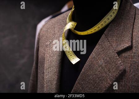 Suit jacket on male tailor mannequin and tape measure, creative concept of clothes atelier Stock Photo