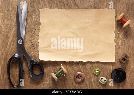 tailor or sewing accessories and supplies with tools at wooden table, creative concept top view Stock Photo