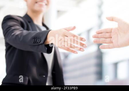 Businesswoman going to make handshake with a businessman -greeting, dealing, merger and acquisition concepts Stock Photo