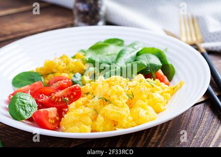 Breakfast. Scrambled eggs with cherry tomatoes, spinach  and corn. Stock Photo