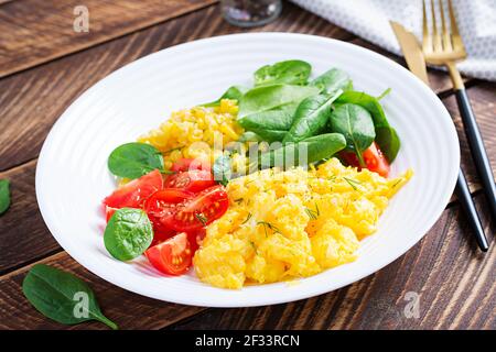 Breakfast. Scrambled eggs with cherry tomatoes, spinach  and corn. Stock Photo