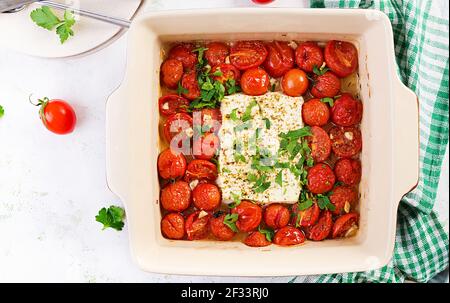 Preparation of ingredients for fetapasta. Trending Feta bake pasta recipe made of cherry tomatoes, feta cheese, garlic and herbs.  Top view, above, co Stock Photo