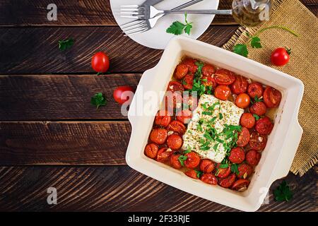 Preparation of ingredients for fetapasta. Trending Feta bake pasta recipe made of cherry tomatoes, feta cheese, garlic and herbs.  Top view, above, co Stock Photo