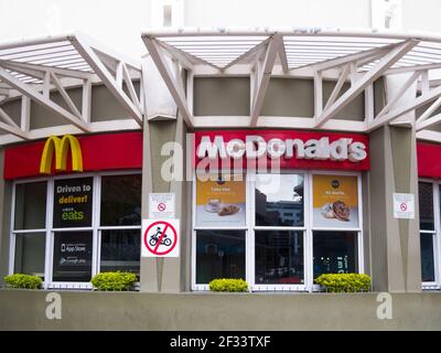 McDonalds fast food franchise outlet closeup with brand name and logo on a building in Cape Town, South Africa Stock Photo