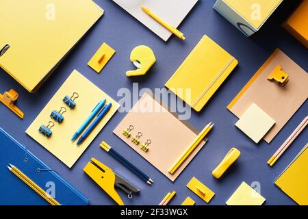 Top view of bright assorted school and office stationery arranged on blue background Stock Photo