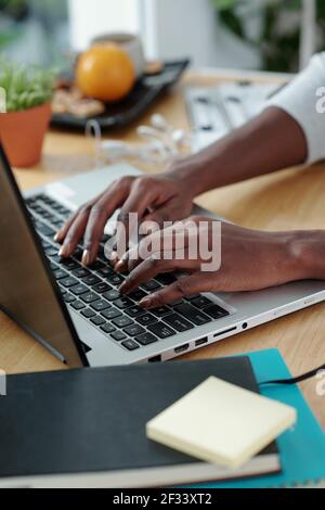 Close-up image of Black businesswoman working on laptop or programming at desk in home office Stock Photo