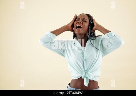 Emotional desperate devastated young woman having nervous breakdown, shouting and touching head Stock Photo