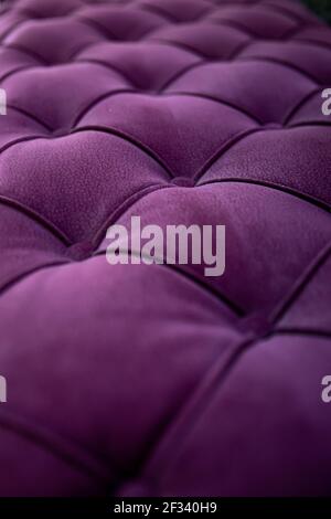 Close up textured purple velvet fabric modern sofa with sunken buttons. Idea and variant of fabric for upholstery sofa. Stock Photo