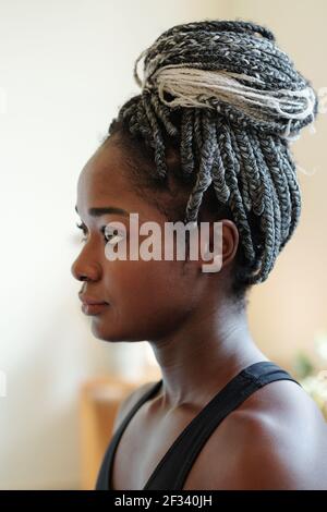 Head of pensive young Black woman with braided hair in bun looking in front of her Stock Photo