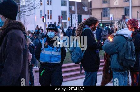 Brighton UK 13th March 2021 - A police liason officer at the candlelit vigil for murder victim Sarah Everard in Brighton this evening . Reclaim These Streets protesters gathered in Brighton's Valley Gardens to take part in the vigil before police started to move them on after about half an hour:  Credit Simon Dack / Alamy Live News Stock Photo