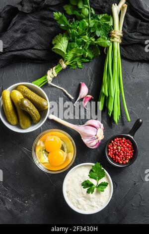 Organic lemon ranch dressing in a small jar with fresh greens. Tartar sauce. Making sauce from capers, cucumbers, parsley, lemon and eggs. For fish an Stock Photo