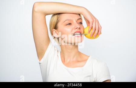 Girl drink fresh juice whole lemon fruit. Healthy lifestyle and organic nutrition. Lemonade fills you with energy. Battery concept. Lemon with hobnail Stock Photo