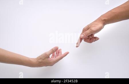 Male and female hands reaching out to each other, creation of adam sign. Isolated on white background. Concept of connection and human relations. Stock Photo