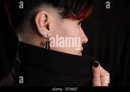 Close up profile portrait of pretty young adult brunette isolated on black background looking away, copyspace Stock Photo