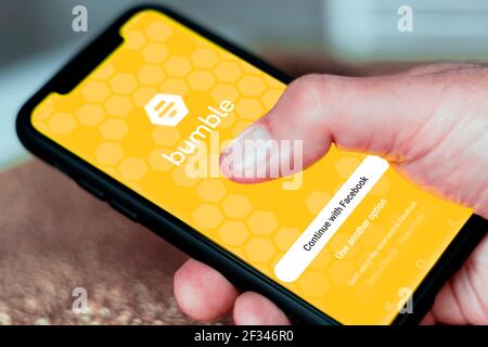 Rome, Italy, february 16th 2021: Hand holding a smart phone with Bumble dating app login page on screen. Social media and virtual relationships. Adult Stock Photo