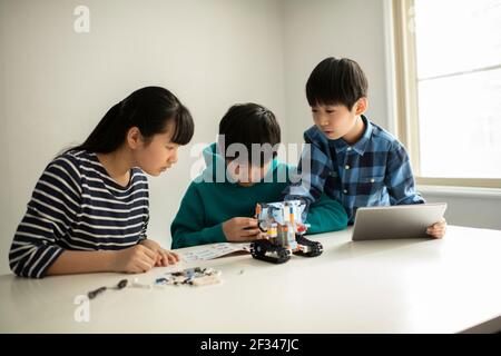 Elementary School Students Assembling Programming Robot Stock Photo