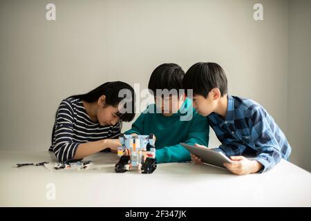 Elementary School Students Assembling Programming Robot Stock Photo