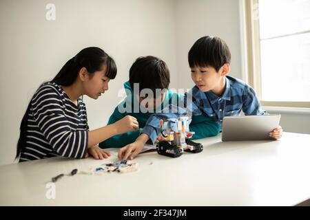 Elementary School Students Assembling Programming Robot Stock Photo
