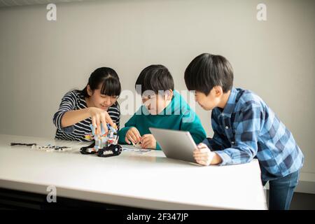 Elementary School Students Assembling Programming Robot Stock Photo