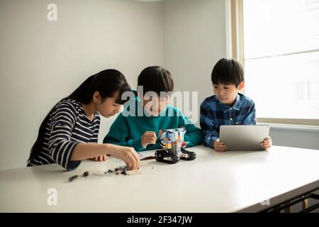 Elementary School Students Assembling Programming Robot Stock Photo