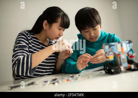 Elementary School Students Assembling Programming Robot Stock Photo