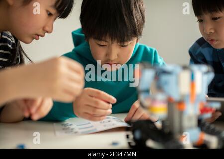 Elementary School Students Assembling Programming Robot Stock Photo